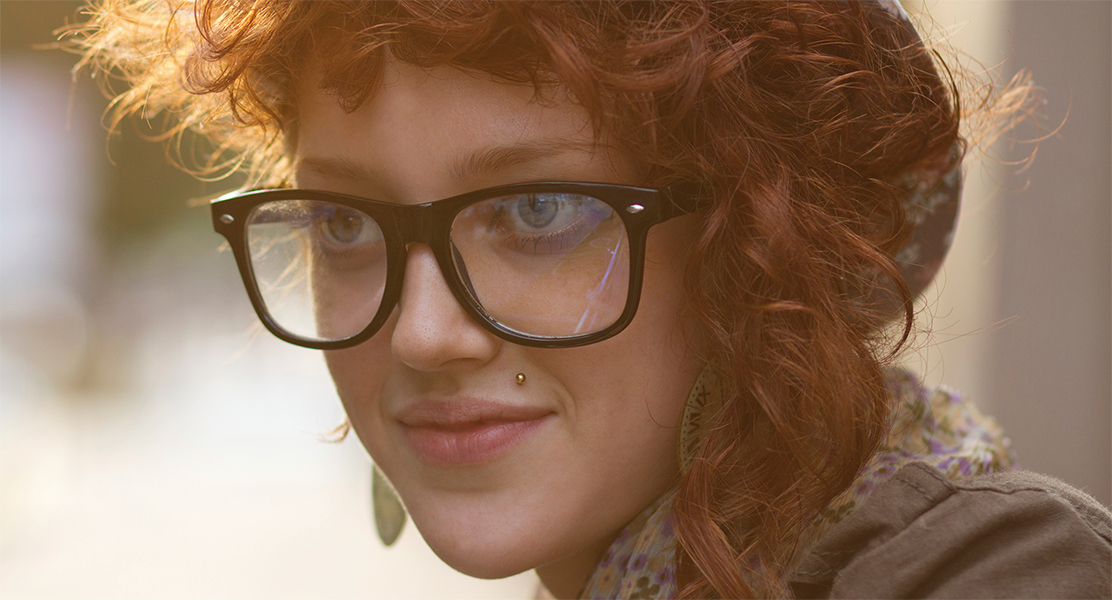 Closeup of young girl with red hair and glasses